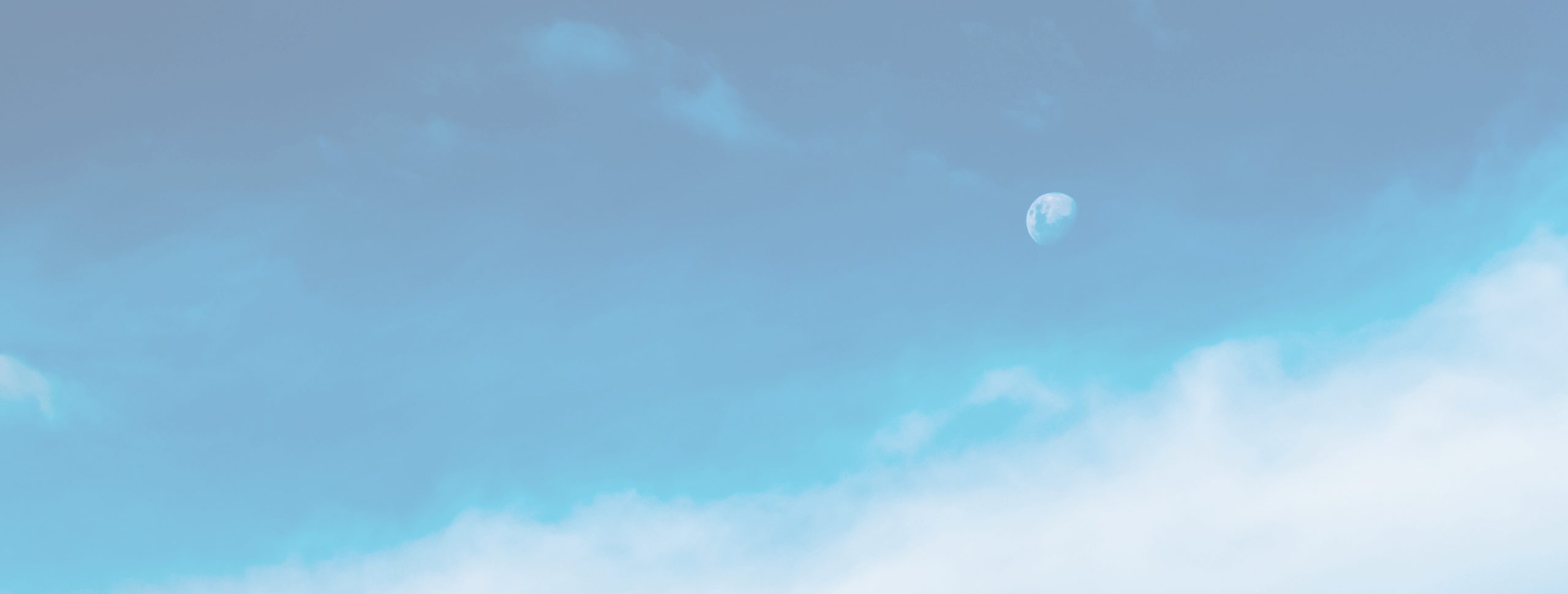 ciel bleu nuageux laissant deviner la lune en train de se lever